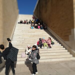 Studenti seduti a piccoli gruppi sulle scalinate del monumento